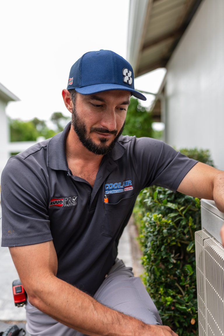 CoolAir technician maintaining an outdoor HVAC system