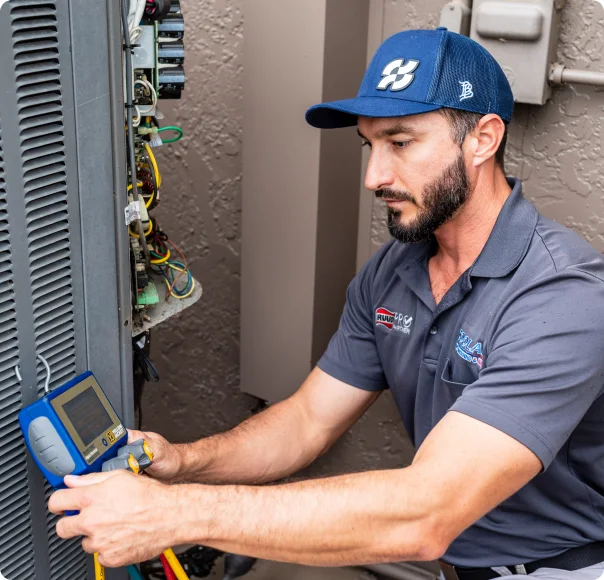 Coolair technician checking an outdoor air conditioning unit with service gauges