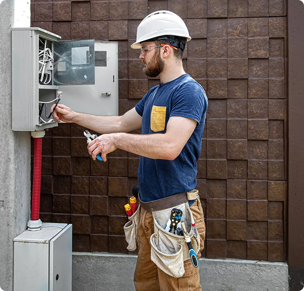 Electrician inspecting an outdoor electrical panel