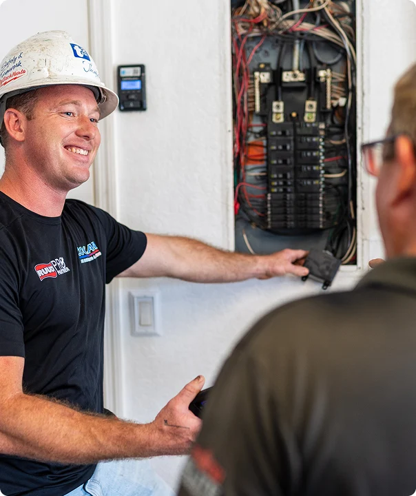 Electrician discussing an electrical panel inspection with a homeowner