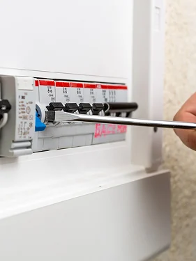 Electrician servicing circuit breakers in an electrical panel