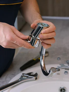 Plumber repairing a bathroom sink drain pipe