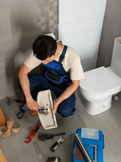 Plumber repairing a bathroom sink during a residential service call