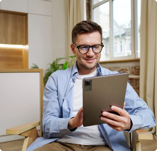 Man reviewing paperwork on a clipboard at a desk.