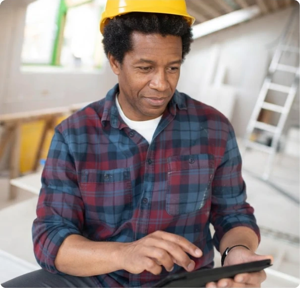 Worker in a hard hat using a tablet